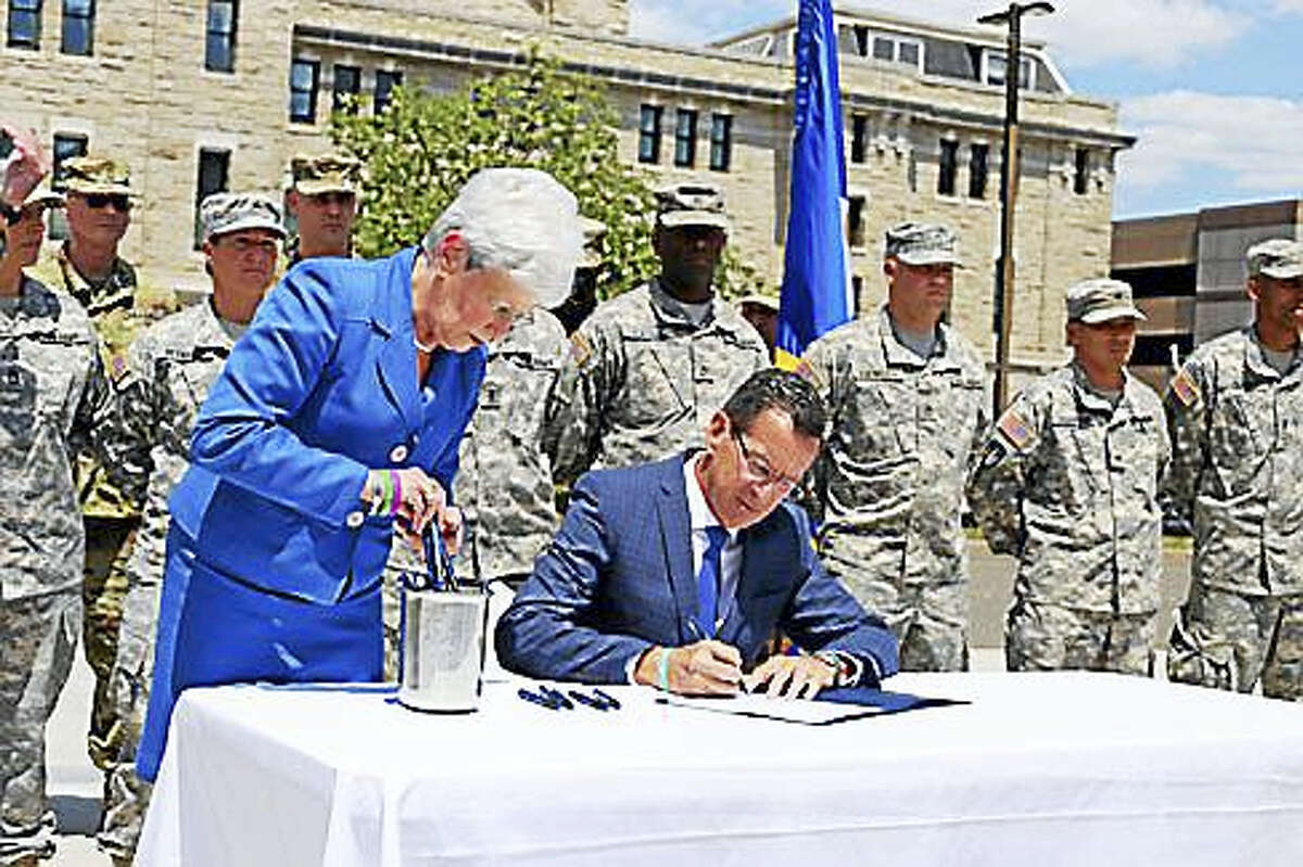 Gov. Dannel P. Malloy, right center, signing the bill with Lt. Gov. Nancy Wyman.