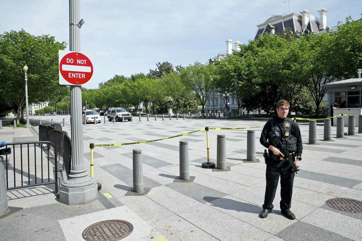 A U.S. Secret Service officer blocks Pennsylvania Avenue at 17th Street near the White House in Washington, Friday, May 20, 2016, after the White House was placed on a security alert after a shooting on a street outside. The Eisenhower Executive Office Building in the background.