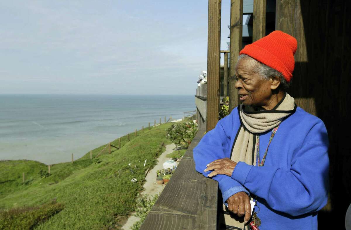 Druth McClure looks out from her deck on a cliff overlooking the Pacific Ocean in Pacifica, Calif. Crumbling cliffs have forced dozens to leave their homes and others like McClure may have to join them as EL Nino-fueled storms batter the coast.