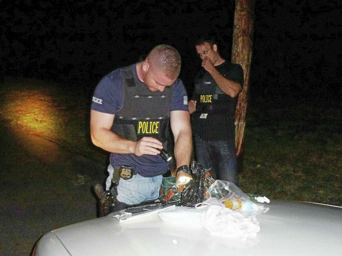 A New Haven police officer searches the purse of a prostitution suspect during a September 2015 sting that led to 27 arrests. No customers were charged as the officers were undercover as “Johns.”