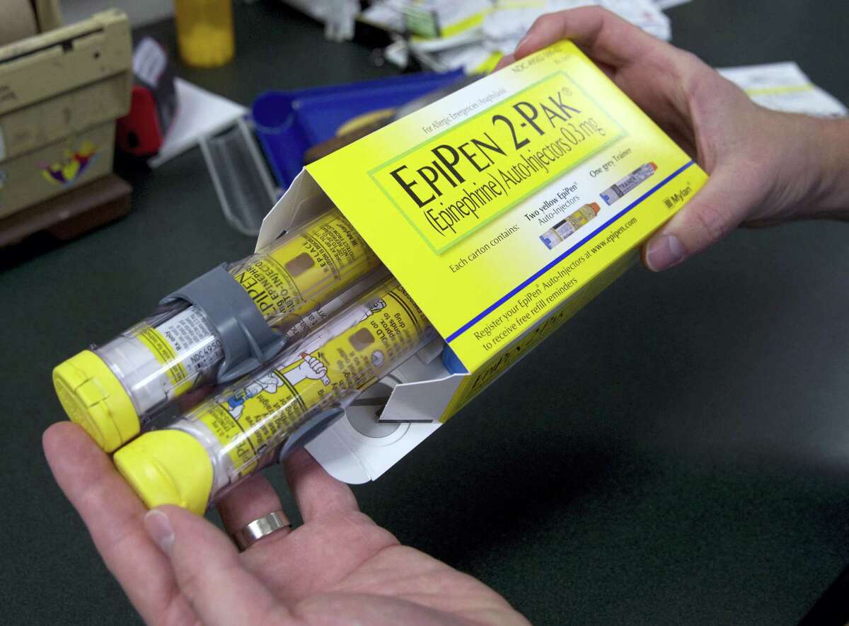 In this July 8, 2016 photo, a pharmacist holds a package of EpiPens epinephrine auto-injector, a Mylan product, in Sacramento, Calif. Mylan CEO Heather Bresch is defending the cost for life-saving EpiPens and is offering no suggestion that there are plans to lower prices. Bresch’s prepared testimony was released by the House Oversight and Government Reform Committee ahead of her Sept. 21 appearance before the panel.
