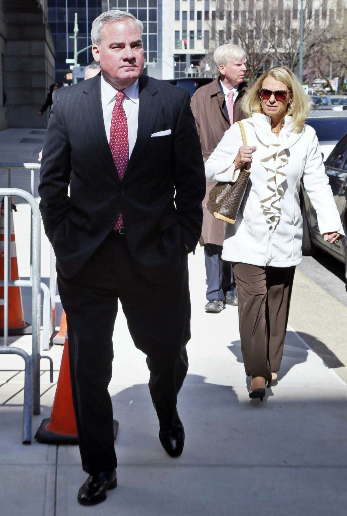 Former Connecticut Gov. John Rowland, left, leaves with his wife Patricia, right, at federal appeals court on Friday, March 18, 2016 in New York. Rowland has asked a federal appeals court to overturn his political corruption conviction.