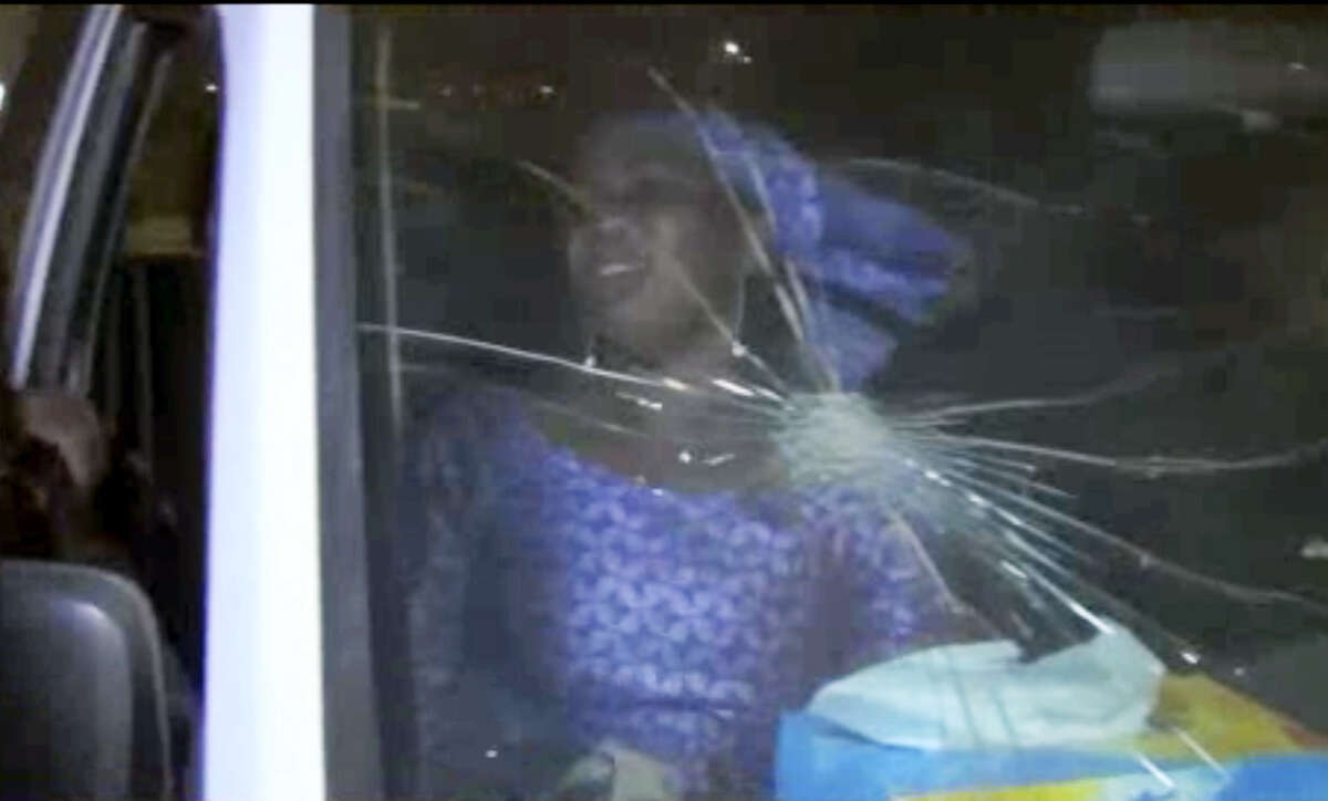 In this image taken from video from AP Television, a rescued woman sits in a vehicle with bullet hole in windshield near the Splendid Hotel, Friday, Jan. 15, 2016, in Ouagadougou, Burkina Faso. The SITE Intelligence Group reports that an al-Qaida affiliate is claiming responsibility for the ongoing siege on an upscale hotel and cafe in Burkina Faso’s capital where an unknown number of hostages are being held.