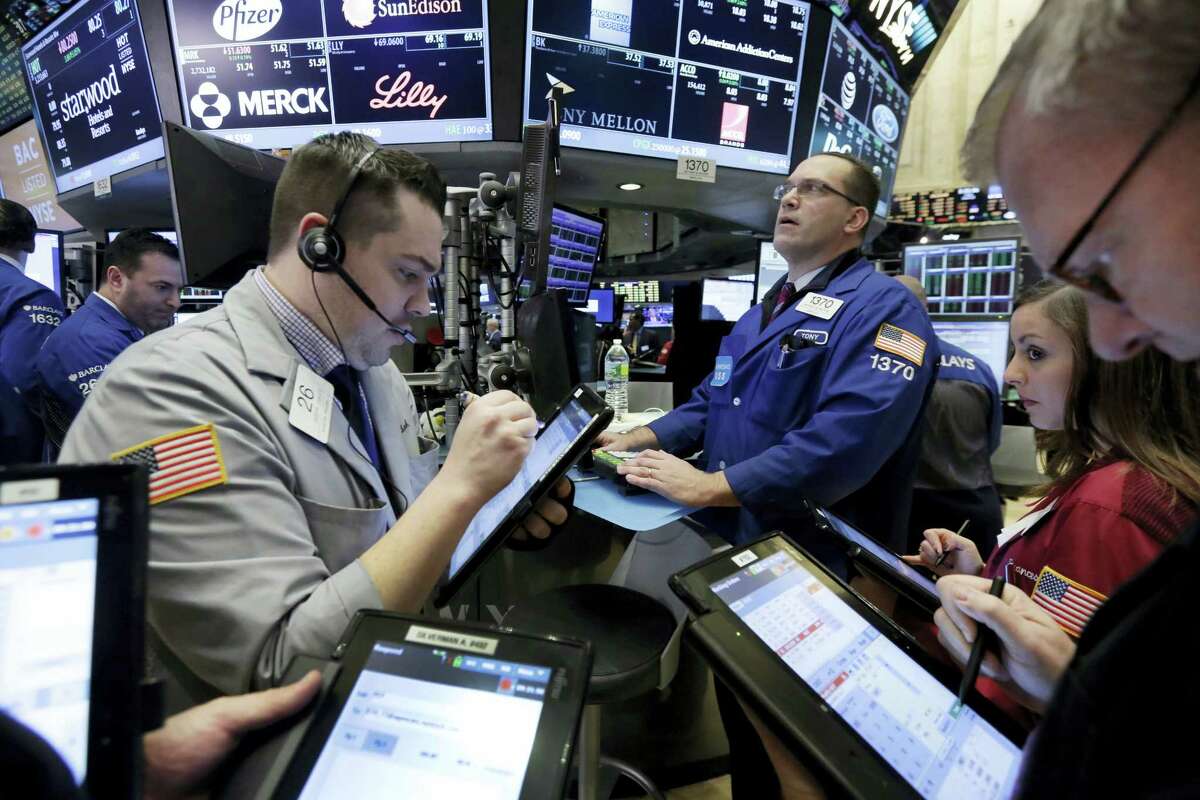 Traders gather at the post of Anthony Matesic, background right, on the floor of the New York Stock Exchange Friday.