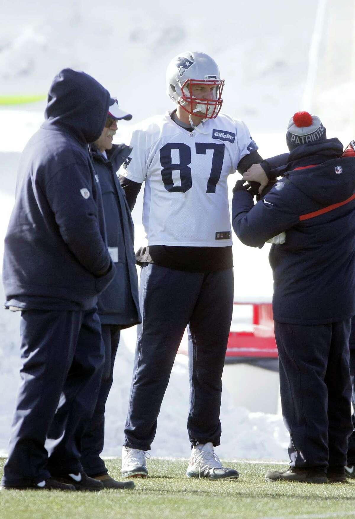 New England Patriots tight end Rob Gronkowski, center, has his arm tended to during practice on Wednesday.