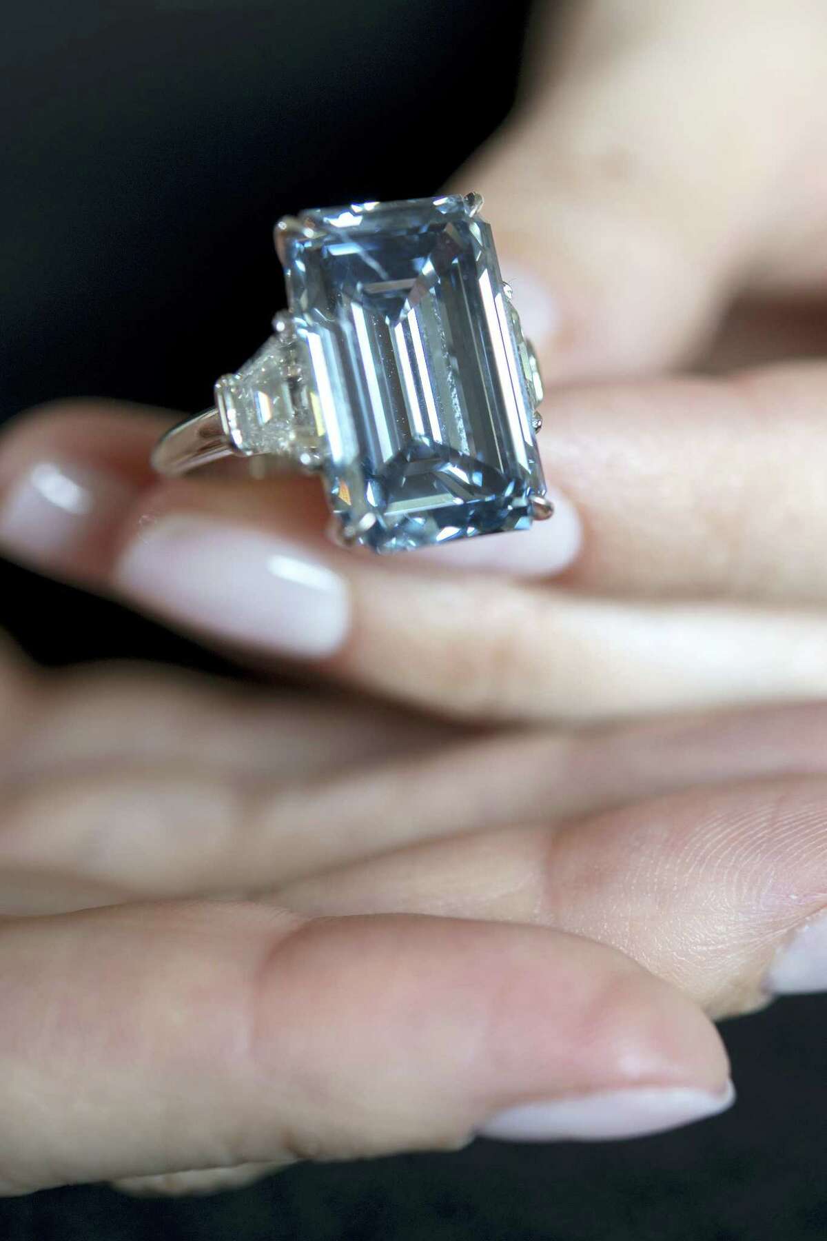 In this May 12, 2016, file picture, a Christie’s employee holds the “Oppenheimer Blue” diamond of 14.62 carats, which is estimated to be sold between 39 to 46 million US dollars, during a preview at the auction house Christie’s, in Geneva, Switzerland. The auction will take place on Wednesday May 18, 2016, in Geneva.