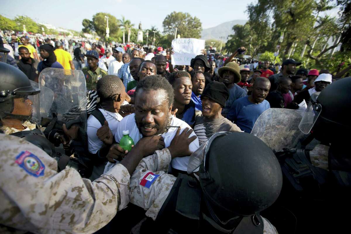 National police officers stop protesters in front of the National Palace during a January protest demanding the resignation of President Michel Martelly in Port-au-Prince, Haiti.