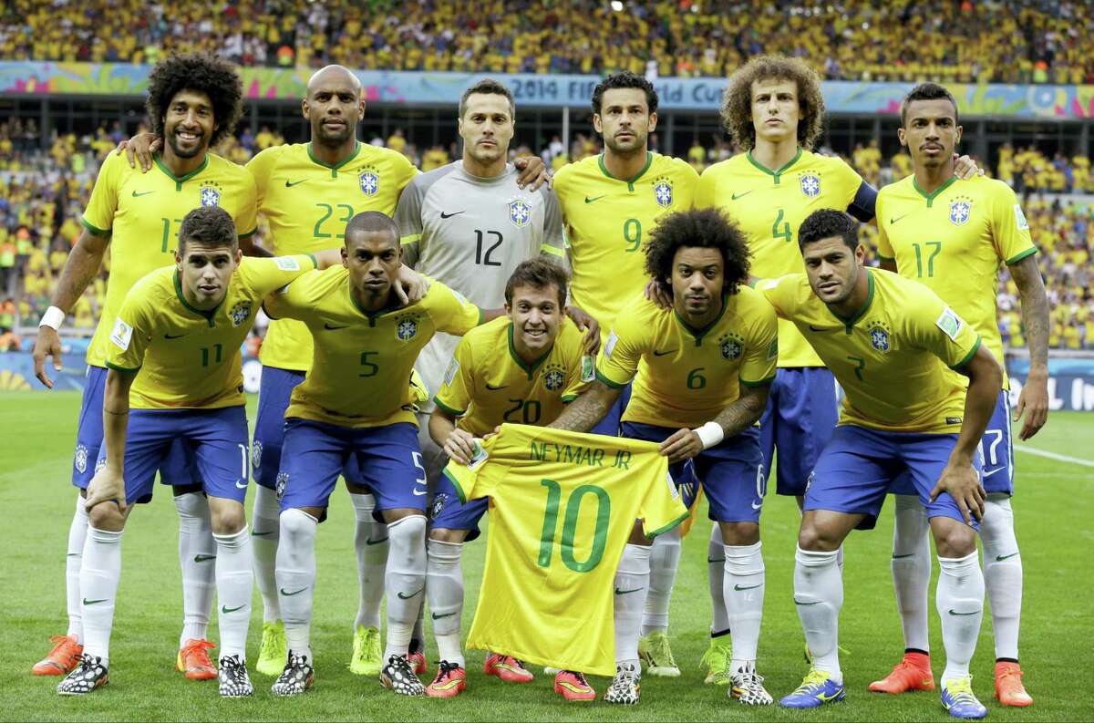 Brazil’s national team holds up Neymar’s jersey as they pose before their World Cup semifinal match with Germany in 2014 in Belo Horizonte, Brazil. Neymar missed the game after breaking a vertebrae.