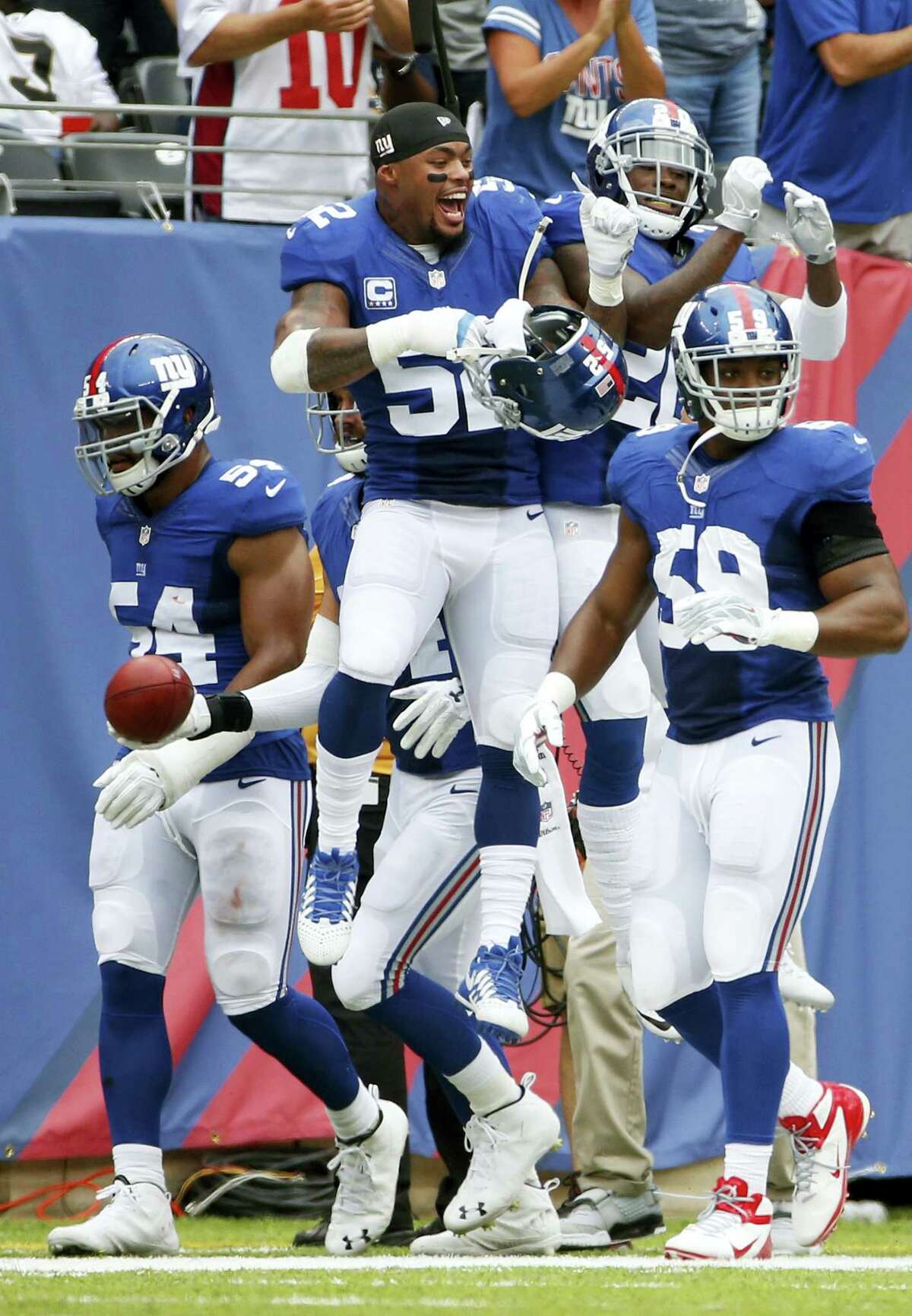 Giants outside linebacker Jonathan Casillas (52) celebrates with teammate Janoris Jenkins and Devon Kennard (59) and Olivier Vernon (54) after Jenkins returned a blocked field goal for a touchdown on Sunday.