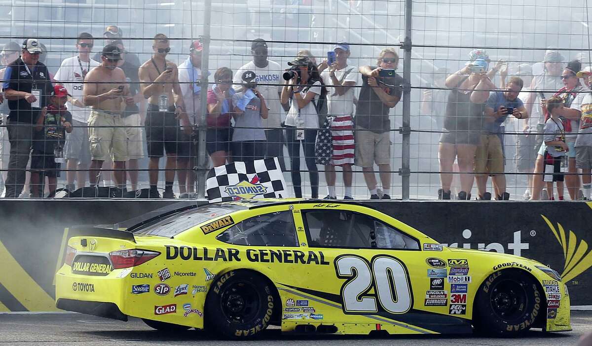 Matt Kenseth drives the checkered flag past fans after winning the New Hampshire 301 on Sunday in Loudon, N.H.