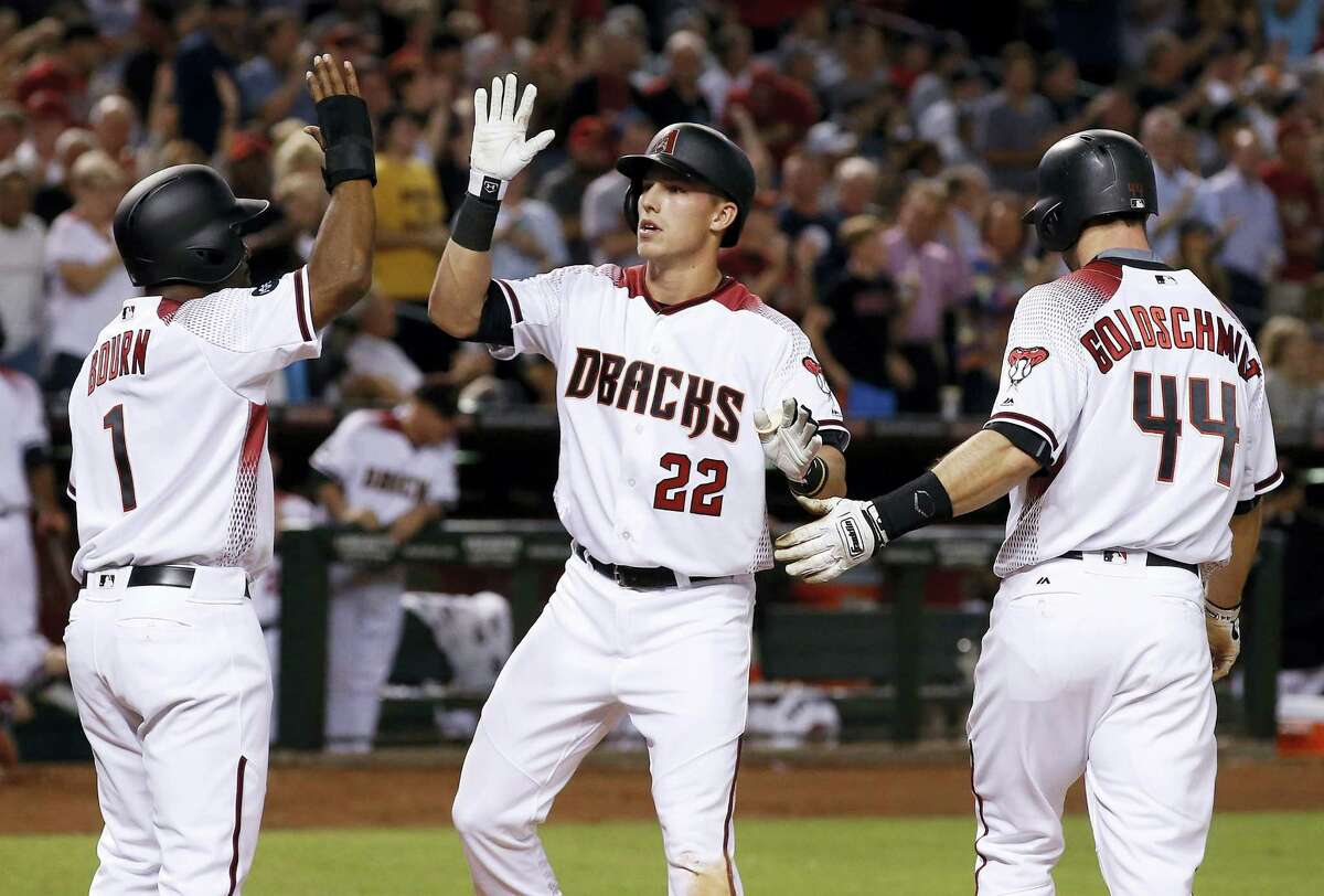 Arizona Diamondbacks’ Jake Lamb (22) arrives at home plate to celebrate his three-run home run against the New York Yankees with Michael Bourn (1) and Paul Goldschmidt (44) during the fifth inning Monday in Phoenix.
