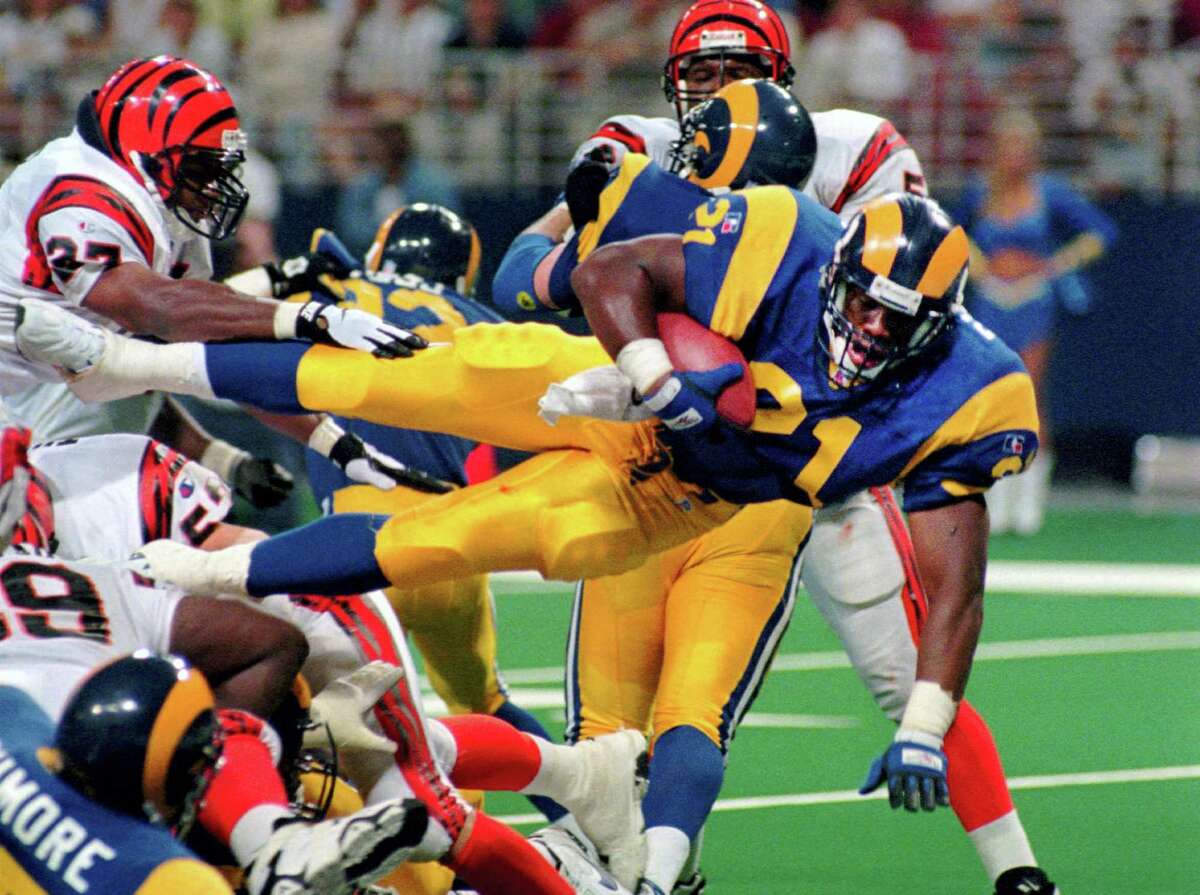 L.G. Patterson — The Associated Press This Sunday, Sept. 1, 1996, file photo shows St. Louis Rams running back Lawrence Phillips (21) leaping over a mound of players as he scores against the Cincinnati Bengals in St. Louis, Mo. Former NFL running back, Phillips was found dead in his California prison cell early Wednesday, Jan. 13, 2016, and officials said they suspect suicide.