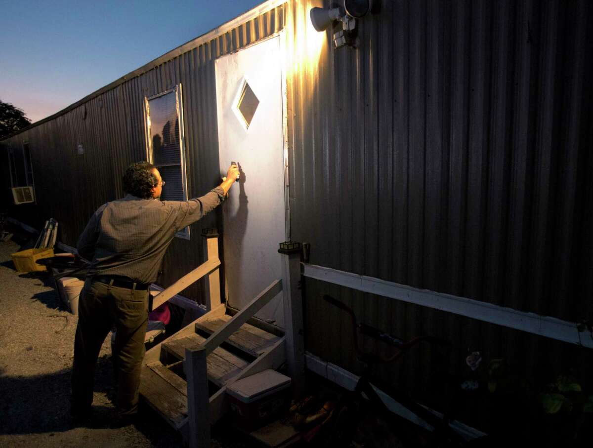 In this Thursday, Nov. 12, 2015, photo, Antonio Tovar-Aguilar, an investigator with the Florida Department of Health, knocks on a farmworker’s door during a follow-up visit in Belle Glade, Fla. Farmworkers are supposed to be protected by government rules regulating exposure to toxic pesticides and herbicides. But an Associated Press review of federal and state enforcement data and other records showed that the system is riddled with problems.