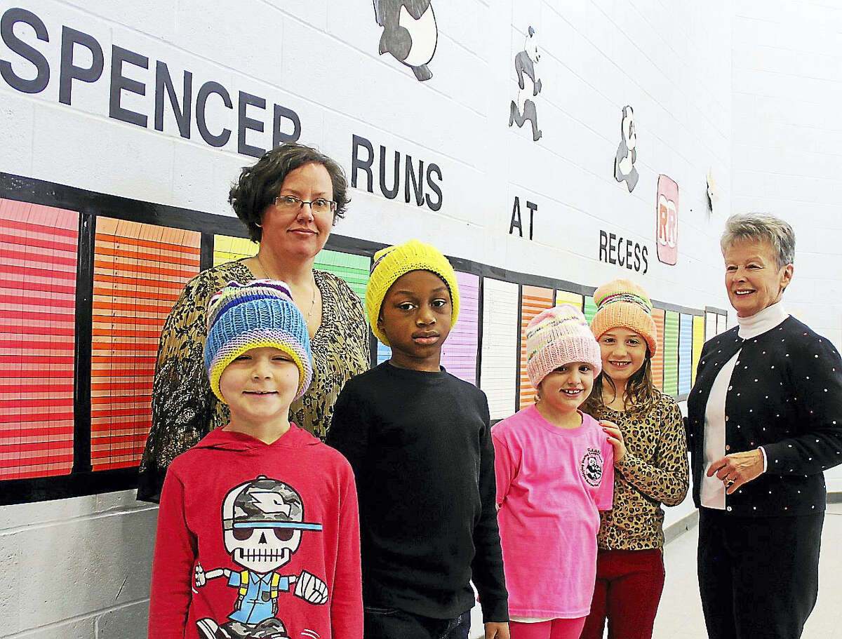 Spencer School students, from left, Devin Morris, Isaiah Anderson, Olivia Roy and Gianna Salafia wear new hats presented by Sarah Duda, rear, and Donna Duda, far right, who crocheted 300, one for every child in her granddaughter’s school.