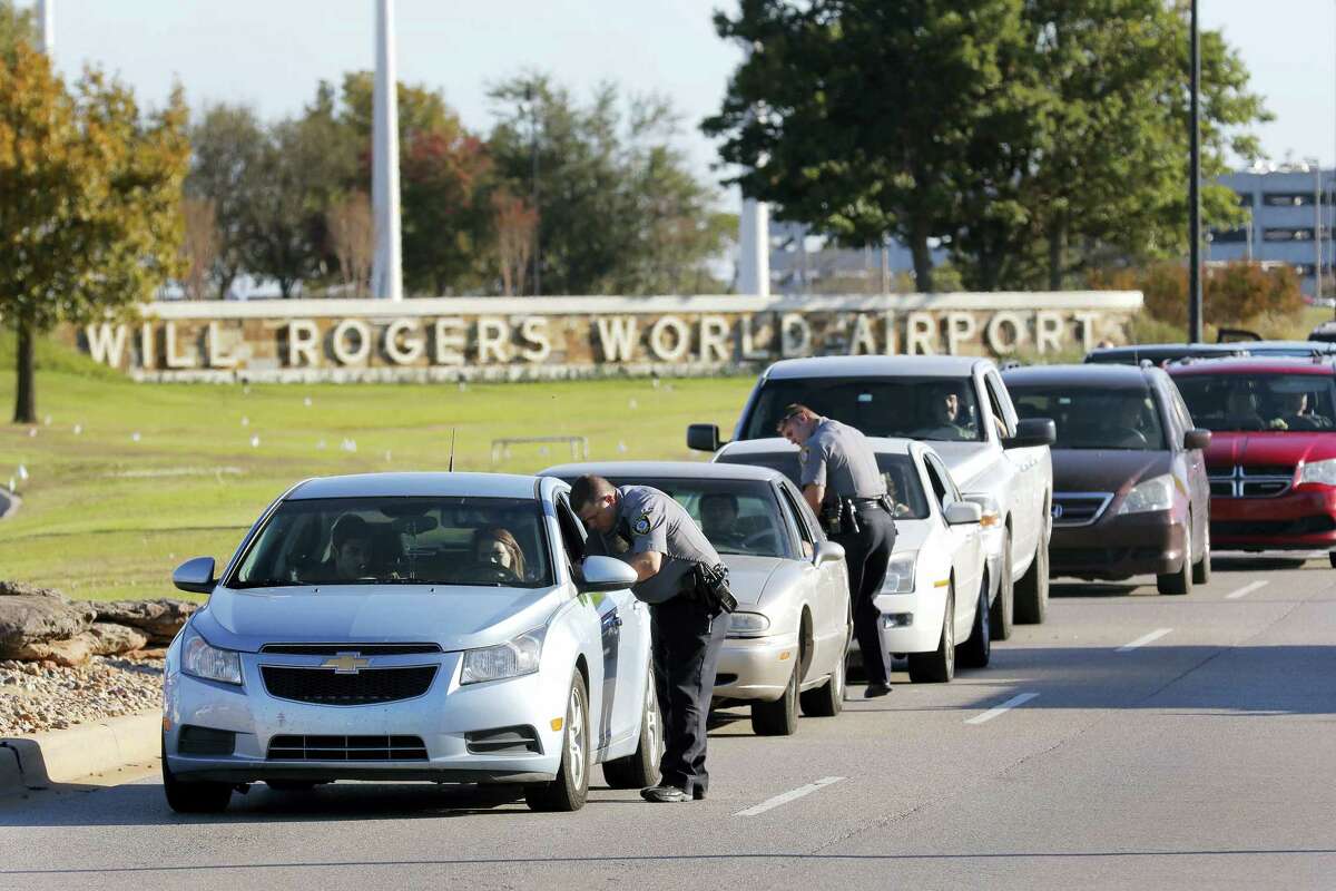 Oklahoma City police officers gather information from vehicles leaving Will Rogers World Airport, Tuesday, Nov. 15 2016, in Oklahoma City. The airport was put on lockdown after a shooting at the main terminal.