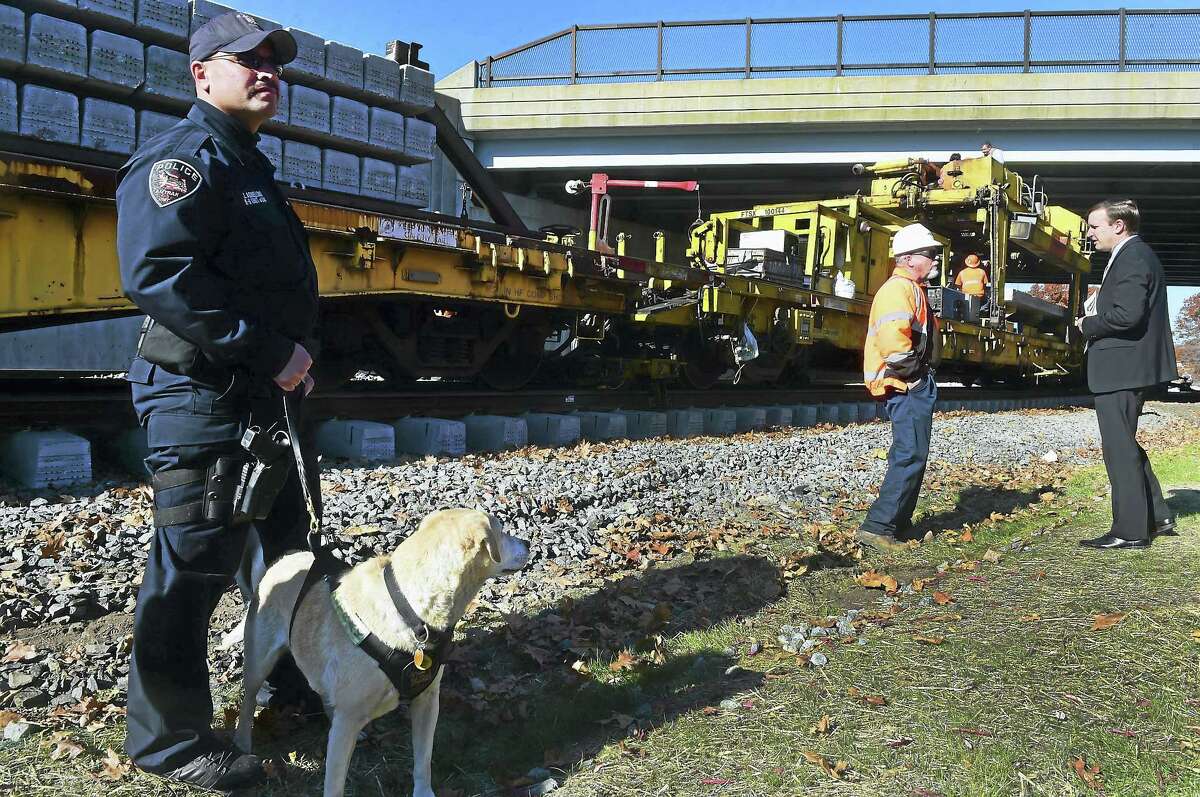 U.S. Sen. Chris Murphy, right, talks with an Amtrak supervisor under the protective eye of Amtrak Police Officer Joseph E. Agnellino and his canine partner Roxy Monday morning as Murphy visits the Hartford Rail Line in Wallingford.