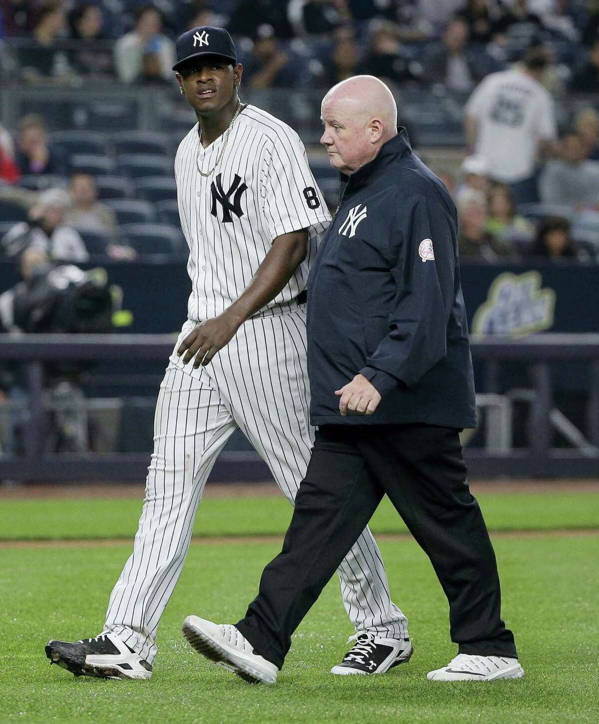 Yankees pitcher Luis Severino, left, walks off the field with head trainer Steve Donohue after giving up a two-run home run against the White Sox on Friday.