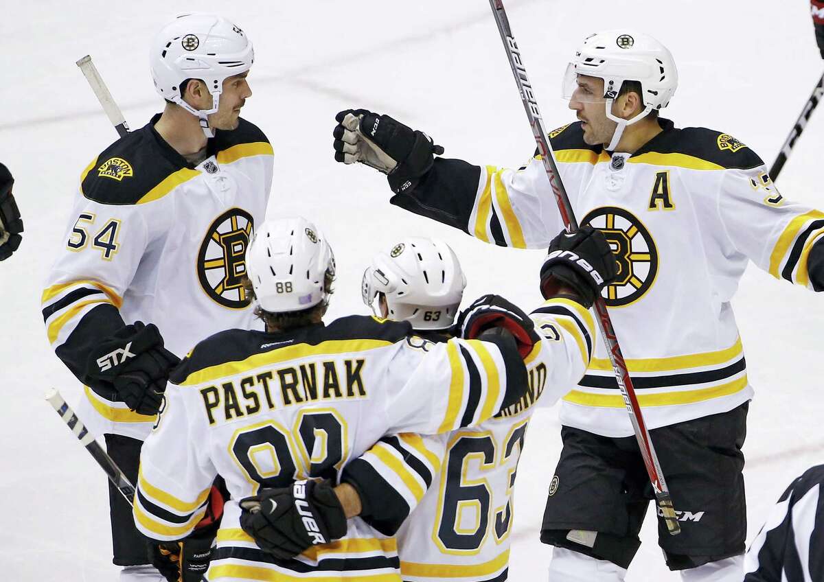 Boston Bruins right wing David Pastrnak (88) celebrates his goal against the Arizona Coyotes with defenseman Adam McQuaid (54), left wing Brad Marchand (63) and center Patrice Bergeron, right, during the second period of an NHL hockey game Saturday, Nov. 12, 2016, in Glendale, Ariz. The Bruins defeated the Coyotes 2-1. (AP Photo/Ross D. Franklin)