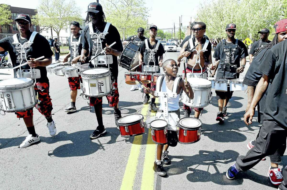 Young Julian Threadgill, center, drums with the New Haven-based Nation Drill Squad and Drum Corp during last year’s parade.