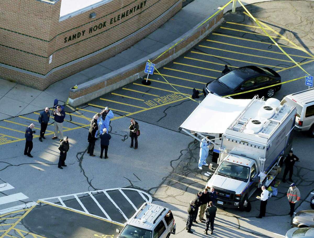 This Dec. 14, 2012, aerial file photo shows officials standing outside of Sandy Hook Elementary School in Newtown.