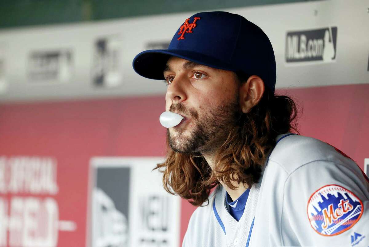 New York Mets starting pitcher Robert Gsellman blows a bubble in the dugout during the fifth inning.
