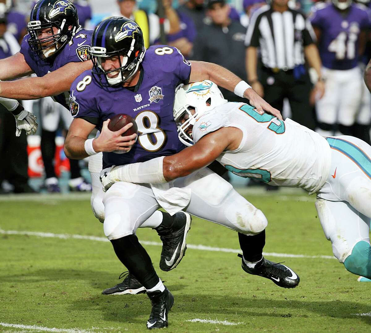 FILE - In this Dec. 6, 2015, file photo, Baltimore Ravens quarterback Matt Schaub (8) is sacked by Miami Dolphins defensive end Olivier Vernon (50), during the second half of an NFL football game, in Miami Gardens, Fla. Defensive end Olivier Vernon's transition tag has been removed by the Dolphins, allowing him to become a free agent hours after the team signed Mario Williams as a replacement. The transition tag was for $12.734 million, but the Dolphins withdrew the offer Wednesday, March 9, 2016, making it likely Vernon will depart after four seasons in Miami. (AP Photo/Wilfredo Lee, File)
