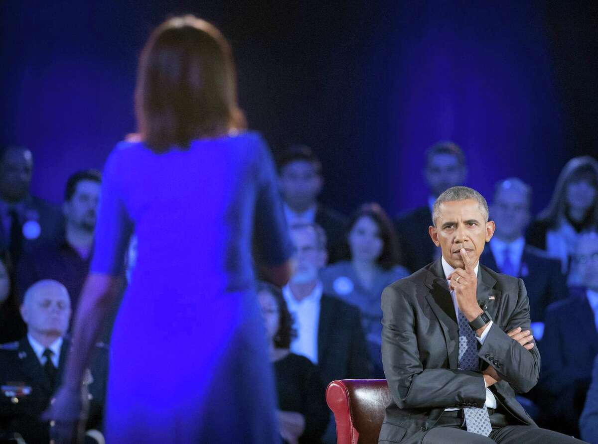 President Barack Obama, right, listens to a question from Taya Kyle, left, widow of U.S. Navy SEAL Chris Kyle, during a CNN televised town hall meeting hosted by Anderson Cooper at George Mason University in Fairfax, Va., Thursday, Jan. 7, 2016. Obama’s proposals to tighten gun controls rules may not accomplish his goal of keeping guns out of the hands of would-be criminals and those who aren’t legally allowed to buy a weapon. In short, that’s because the conditions he is changing by executive action are murkier than he made them out to be.