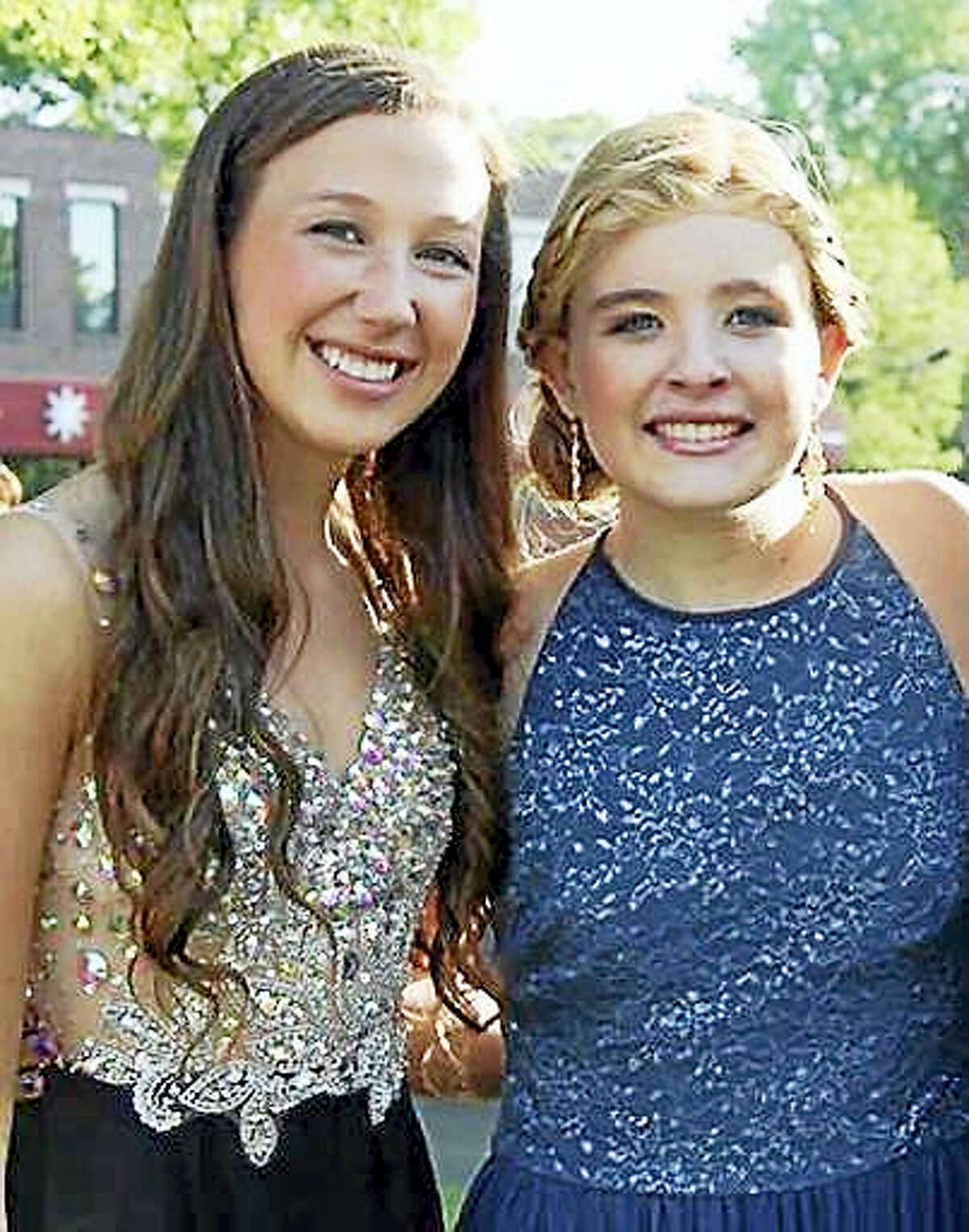 In this May 29, 2015 photo provided by Bonnie Hourican, her daughter Lauren Hourican, left, poses with Catherine Malatesta before the junior prom at Arlington High School in Arlington, Mass. After Catherine died from a rare cancer on Aug. 2, 2015, some of Catherine’s friends, including Lauren, decided to wear her gown to their own proms in 2016 in Catherine’s honor.