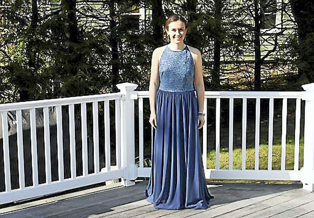 In this April 15, 2016 photo provided by Jennifer Goodwin, Jillian Dalton wears Catherine Malatesta’s prom dress at her home in Arlington, Mass., before attending the Arlington High School prom. After Catherine died from a rare cancer on Aug. 2, 2015, her friends decided each of them would wear Catherine’s gown to their own proms to honor her and remember the happiness she exuded on that special night.