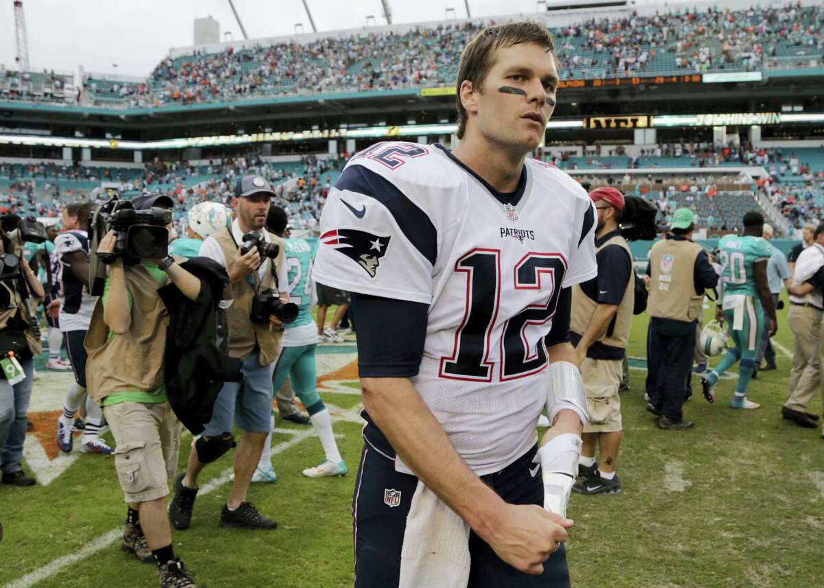 Patriots quarterback Tom Brady (12) leaves the field after Sunday’s loss to the Dolphins in Miami.