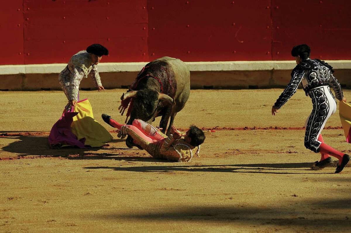 Spanish bullfighter, Francisco Marco, bottom right, is helped by the assistants after being gored by a bull from the Jose Escolar Gil ranch in the bullring during the San Fermin Festival, in Pamplona, northern Spain, Saturday, July 9, 2016. Revelers from around the world flock to Pamplona every year to take part in the eight days of the running of the bulls.
