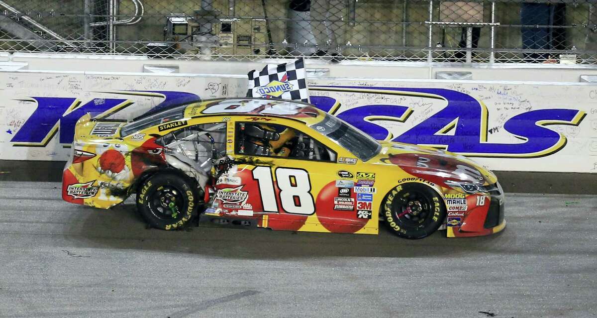 Kyle Busch celebrates with the checkered flag after winning at Kansas Speedway on Saturday night.