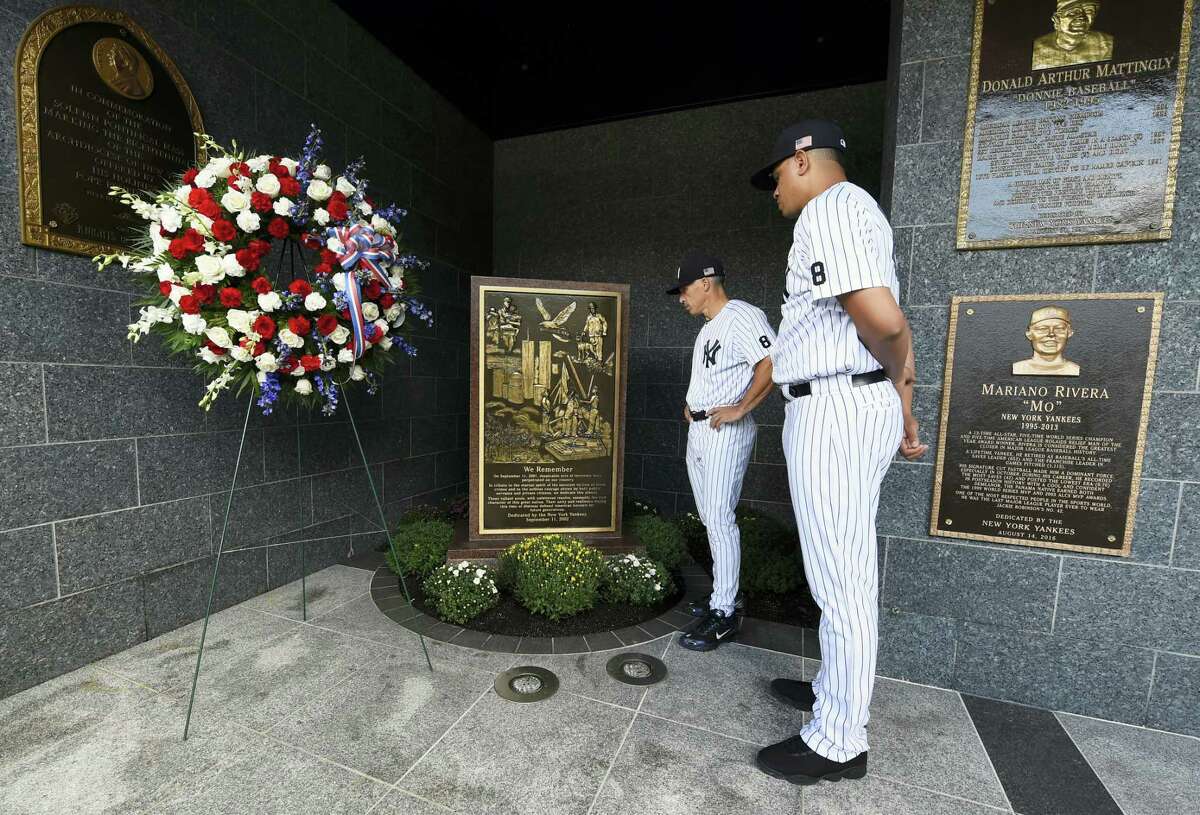 Yankees manager Joe Girardi, left and pitcher Dellin Betances view the September 11th memorial in Monument Park after placing a wreath next to it on Sunday.