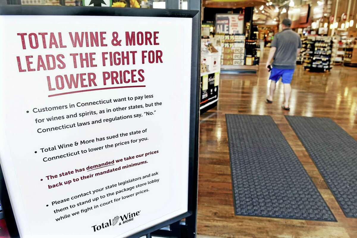 A sign displayed in the entrance to Total Wine & More in Milford Friday details the store’s opposition to Connecticut’s minimum pricing law for wines and spirits.