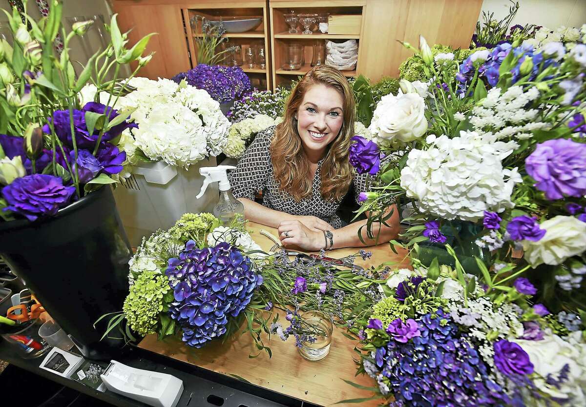 Catherine Avalone/New Haven Register Elise Samson, owner of Elise Floral, uses an assortment of hydrangea, lisianthus, limonium, statice, roses and eucalyptus to create a unique wedding arrangement.