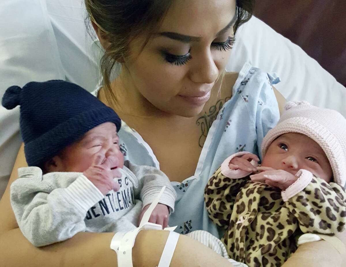 This Jan. 1, 2016 photo provided by Kaiser Permanente San Diego shows Maribel Valencia holds her newborn twins at the San Diego Kaiser Permanente Zion Medical Center in San Diego. Jaelyn, right, and Luis Salgado, who were born just minutes apart, but in different years. Jaelyn was born in the last minute of New Year’s Eve 2015 and Luis in the first few minute of New Year’s Day 2016.