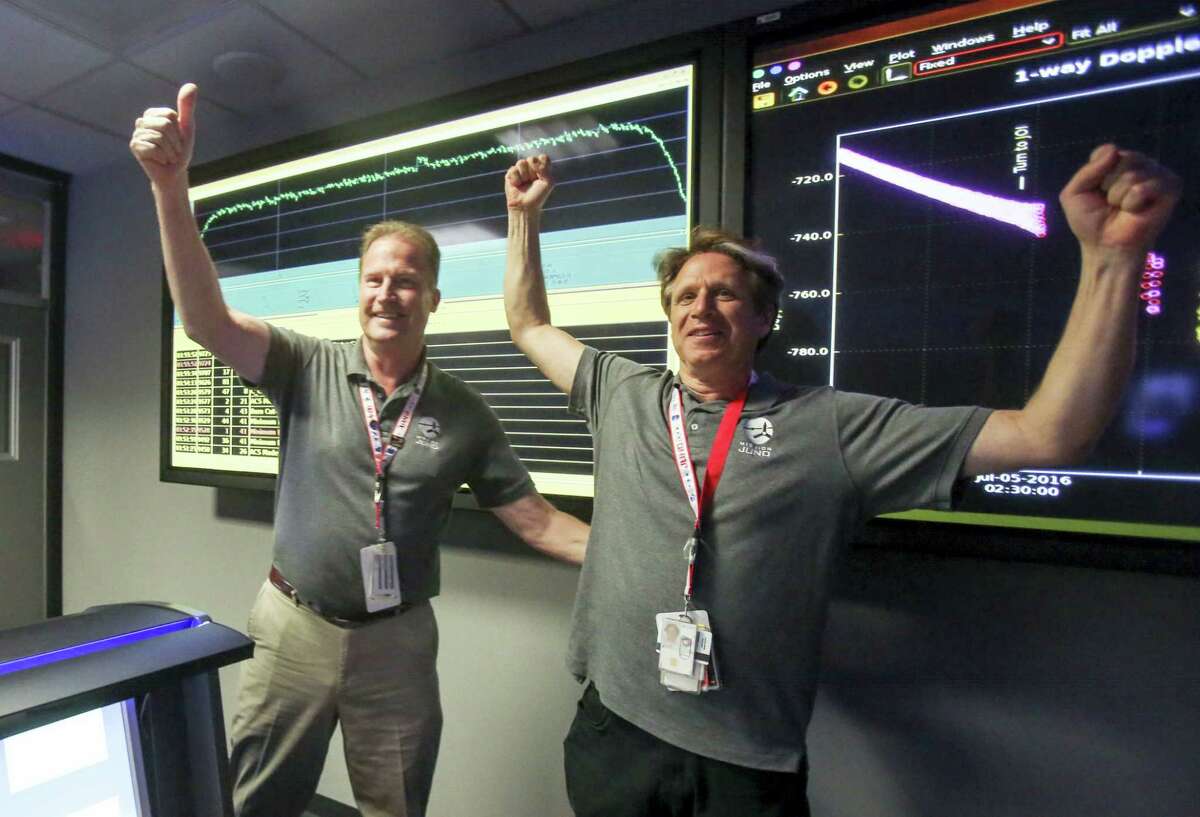 Scott Bolton, right, and Michael Watkins react in Mission Control at NASA’s Jet Propulsion Laboratory as the solar-powered Juno spacecraft goes into orbit around Jupiter on Monday.