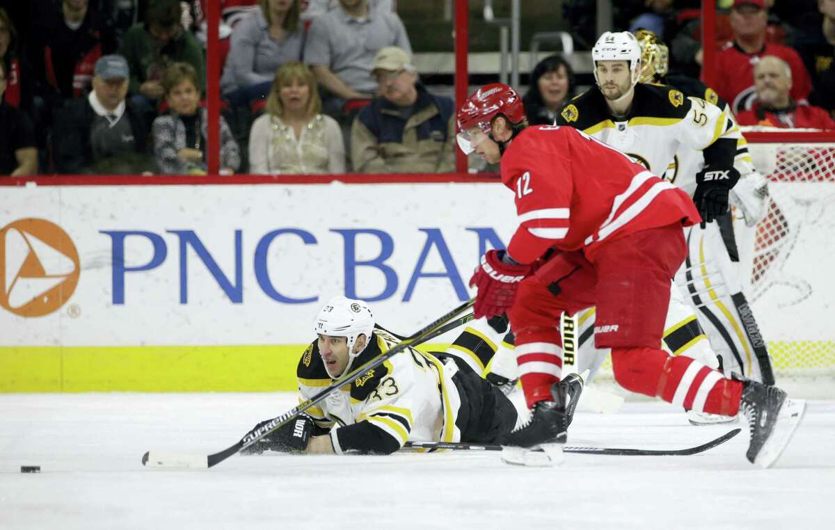 Carolina Hurricanes’ Eric Staal (12) is chased by Boston Bruins’ Zdeno Chara (33) Friday. Staal was traded to the Rangers on Sunday.