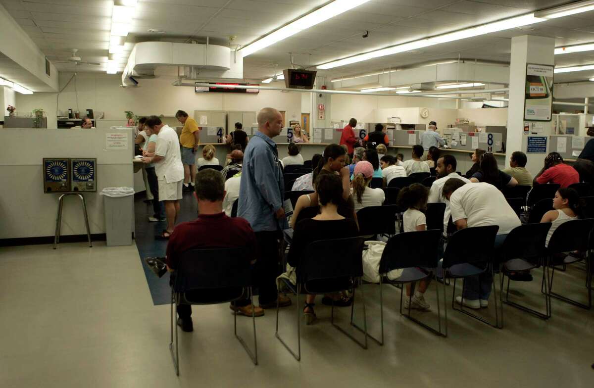 People wait to transact business at the Wethersfield office of the state Department of Motor Vehicles.