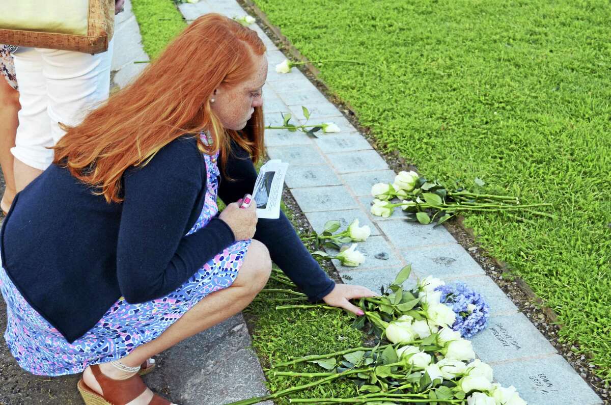 TOM HENRY — WESTPORT MINUTEMAN Emma Hunt, 16, places flowers at the granite stone that honors her father, William Christopher Hunt, who was working in the South Tower of the World Trade Center when it collapsed on Sept. 11, 2001.