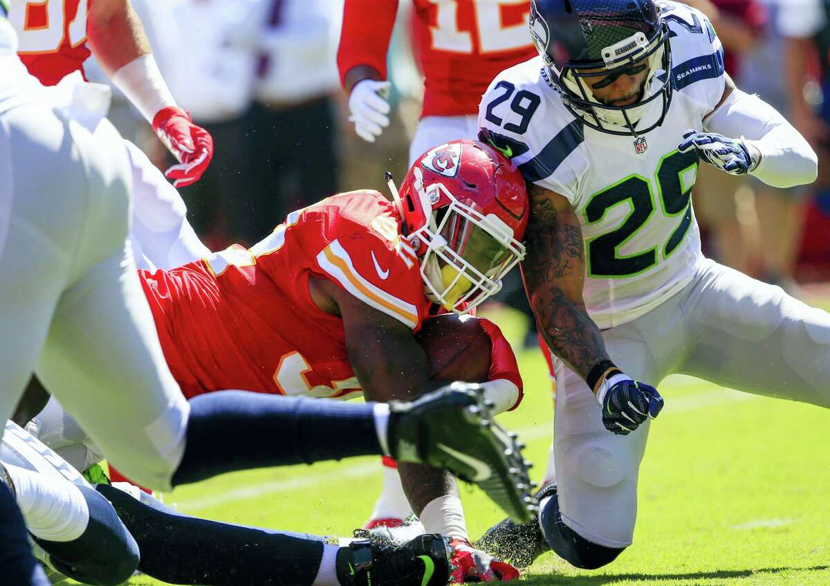 In this Aug. 13, 2016 photo, Kansas City Chiefs running back Spencer Ware (32) is tackled by Seattle Seahawks safety Earl Thomas (29) during the first half of an NFL preseason football game in Kansas City, Mo.