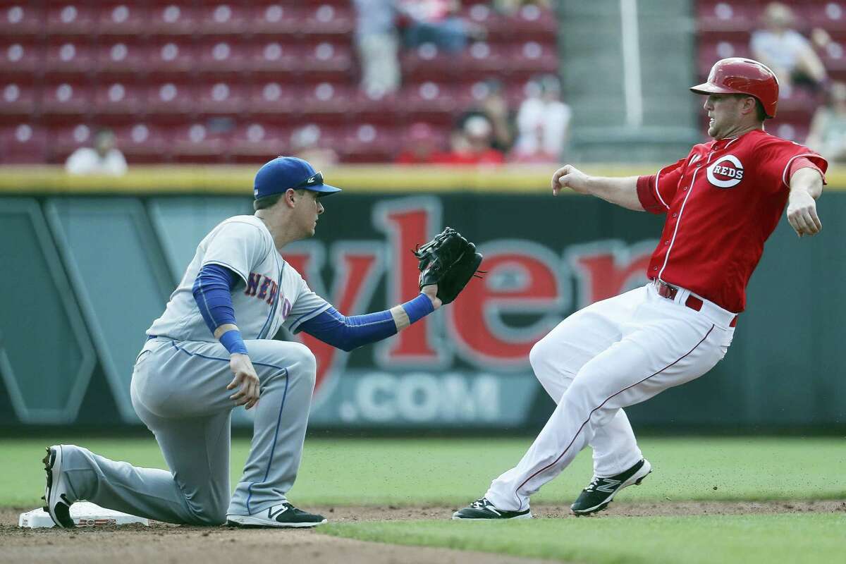 New York shortstop Matt Reynolds, left, tags out Cincinnati Reds’ Scott Schebler in the second inning Wednesday. The Mets won 6-3.