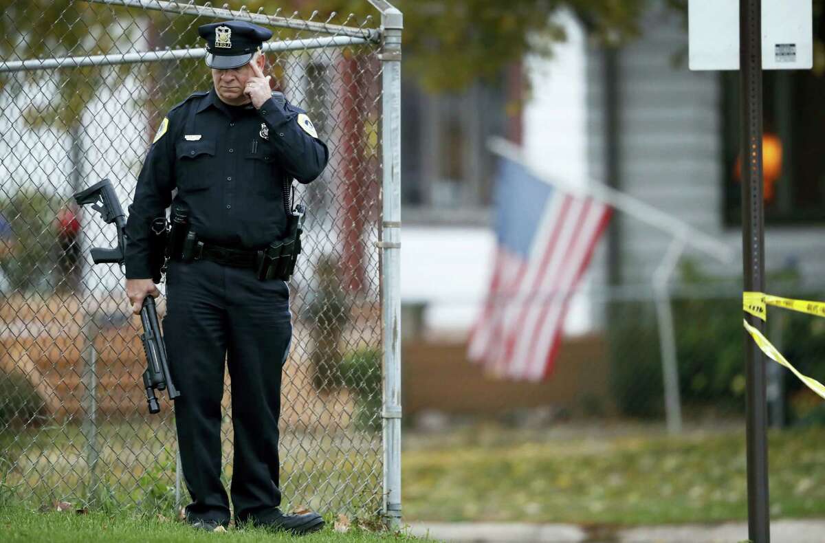 A Des Moines police officer stands near the scene of a shooting, Wednesday, Nov. 2, 2016, in Des Moines, Iowa. Authorities apprehended a man Wednesday suspected in the early morning killings of two Des Moines area police officers who were shot to death while sitting in their patrol cars in what authorities described as separate ambush-style attacks.