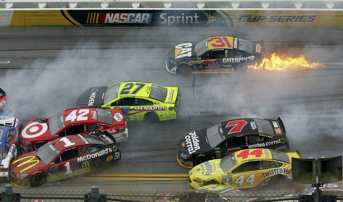 Flames trail from the car of Ryan Newman (31) after a pileup of crashed cars around the track during the NASCAR race at Talladega Superspeedway Sunday in Talladega, Ala.