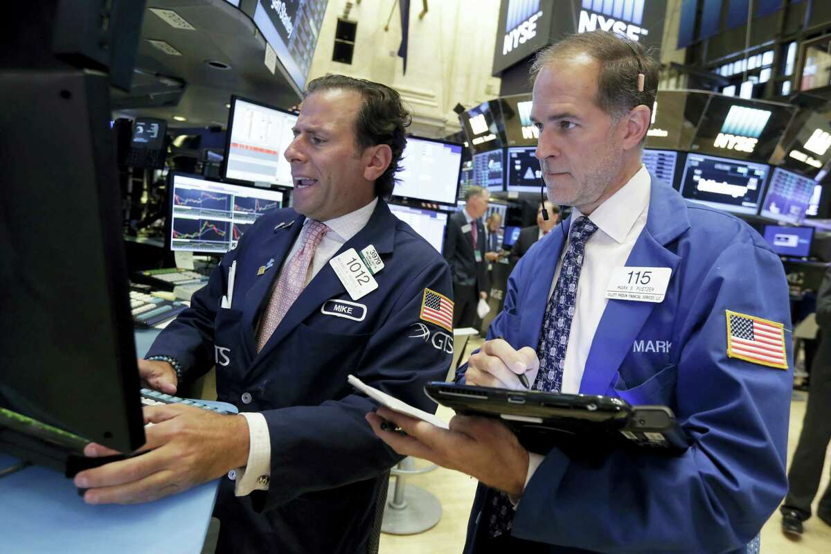 Specialist Michael Pistillo, left, and trader Mark Puetzer work on the floor of the New York Stock Exchange Tuesday.
