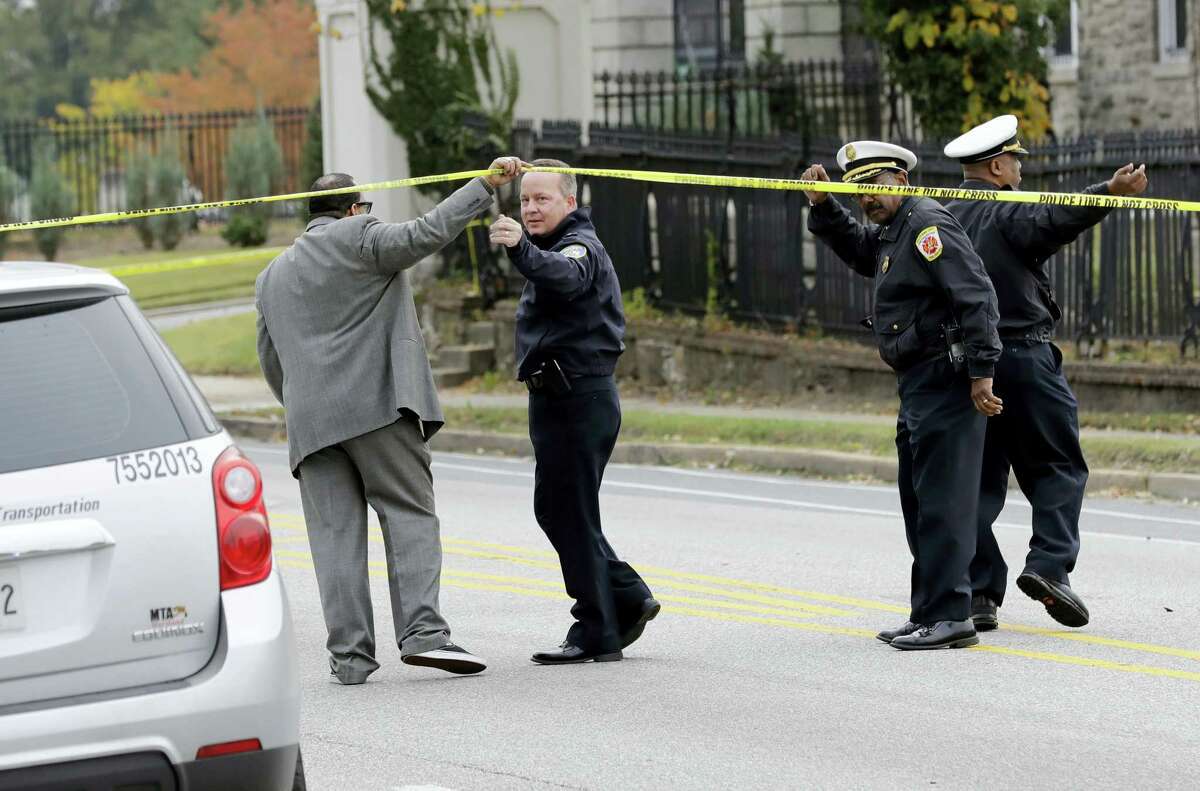 Baltimore Police Department commissioner Kevin Davis, second from left, approaches the scene of an early morning fatal collision between a school bus and a commuter bus in Baltimore, Tuesday, Nov. 1, 2016. Baltimore police spokesman T.J. Smith said the school bus rear ended a car Tuesday morning, then struck a pillar at a cemetery and veered into oncoming traffic, hitting the Maryland Transit Administration bus on the driver’s side.