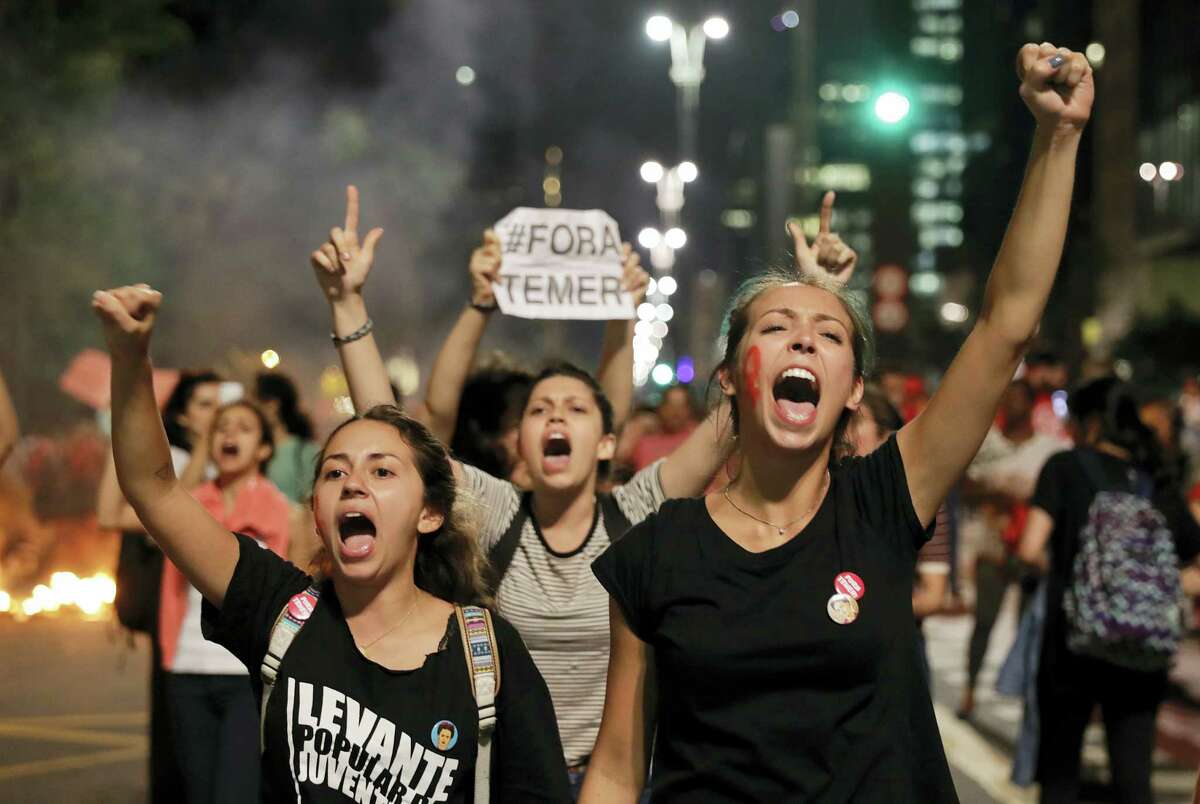 Demonstrators shout slogans against acting Brazil’s President Michel Temer during a rally in support of Brazil’s suspended President Dilma Rousseff in Sao Paulo, Brazil, Monday, Aug. 29, 2016. Police fired tear gas against the demonstrators. Fighting to save her job, Rousseff appeared before congress for her impeachment trial, to defend herself as her accusers say she hurt the economy with budget manipulations. (AP Photo/Andre Penner)