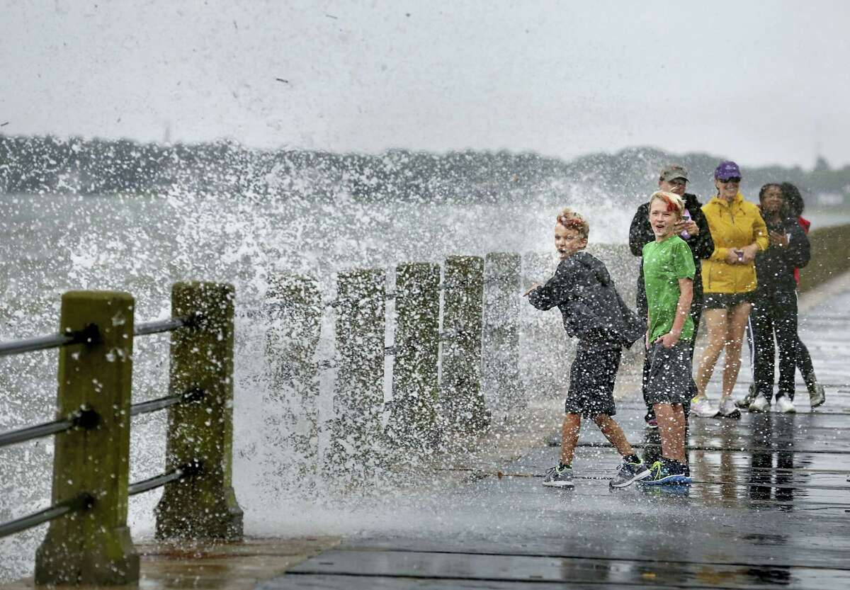 Brothers Trey Bowers,10 and Tyler Bowers,12, are splached with salt water from a crashing wave from Tropical Storm Hermine, Friday, Sept. 2, 2016, in Charleston, S.C.