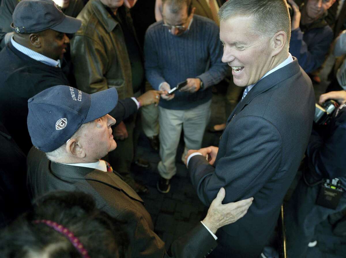 Randy Edsall talks with fan Milton Porter of Hebron, left, after a Friday’s news conference.