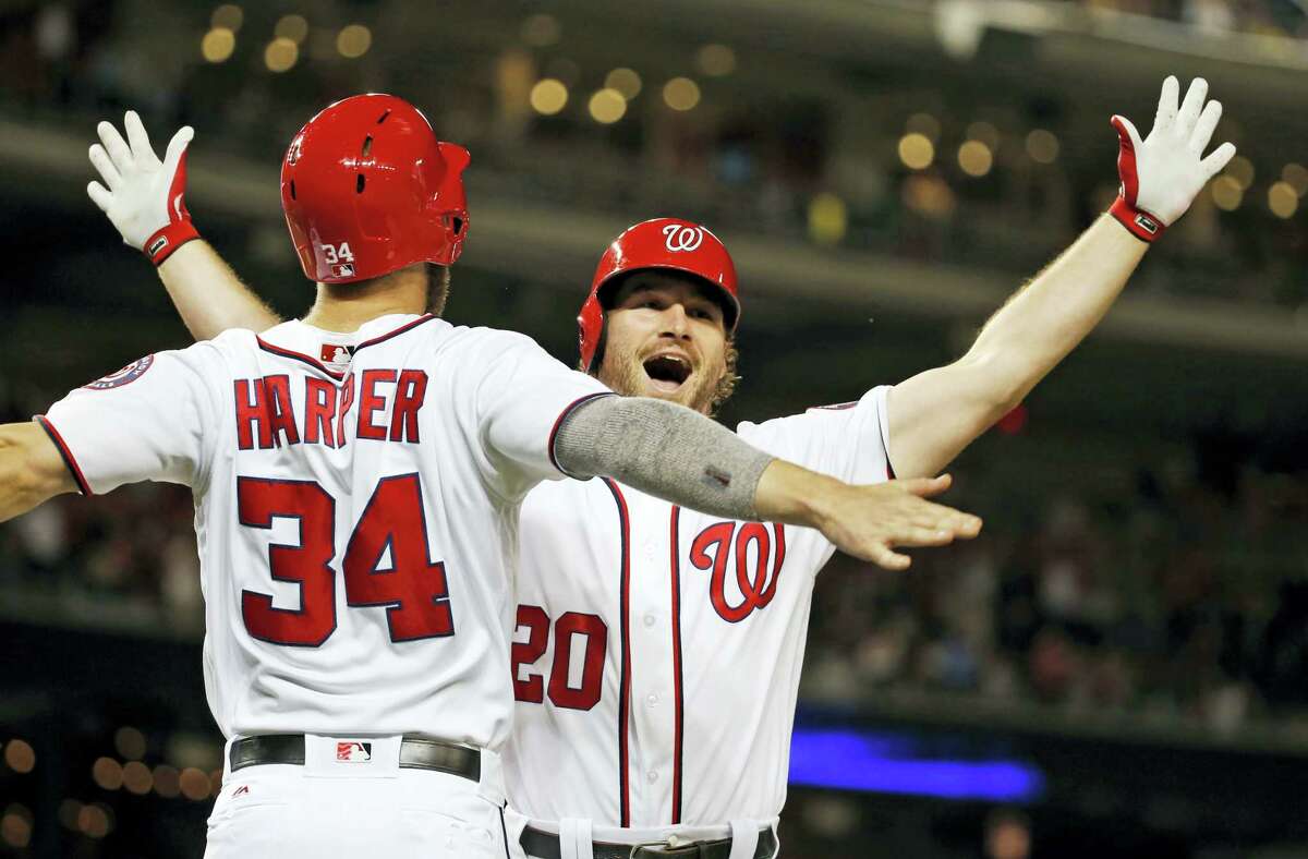Washington Nationals’ Bryce Harper (34) celebrates with Daniel Murphy (20) after Murphy’s two-run home run during the eighth inning against the New York Mets at Nationals Park, Wednesday. The Nationals won 4-2.